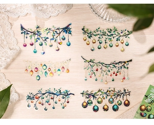Close-up of PET laser Christmas tree stickers with colorful hanging balls on wood