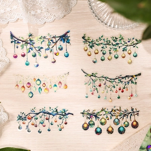 Laser PET stickers with colorful tree branch and bauble designs on light wood background