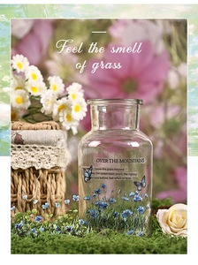 Close-up of decorative floral glass bottle with butterfly prints for botanical DIY scrapbooking