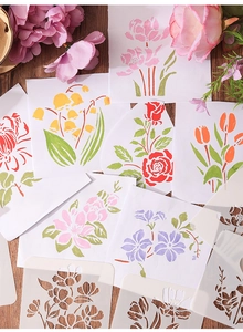 Detail of floral hollow stencils showing flexible plastic material and painted rose patterns