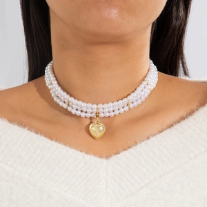 Three-layer pearl necklace featuring a glossy gold heart pendant for a vintage look