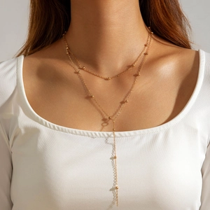 Double-layered golden Y-necklace featuring metallic beads and minimalist tassel design