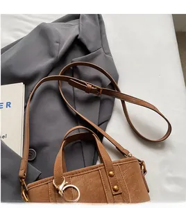Close-up of retro brown leather bucket bag with litchi texture and vintage bronze hardware