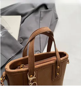 Macro shot of brown leather tote bag handles with gold rivets and smooth zipper detail