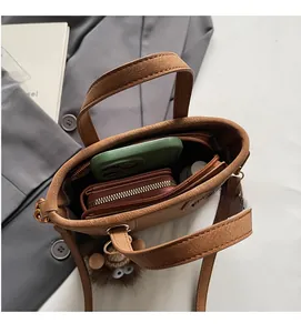 Top view of brown faux leather bucket bag showing spacious interior with phone and wallet