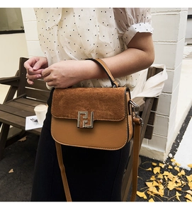 Close-up of brown patchwork crossbody bag with suede texture and silver metal buckle