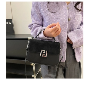 Detail of black crossbody bag with suede patchwork and silver geometric buckle finish