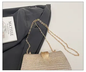 Detail of gold leaf clasp and shimmering sequin texture on a luxury evening clutch bag