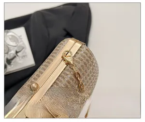 Detail of elegant gold leaf hardware clasp and glittery fabric on a clutch bag