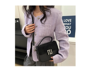 Detail of black leather saddle bag with suede flap and silver geometric metal buckle