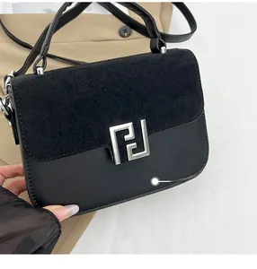 Detail of black matte leather handbag with suede flap and silver geometric metal buckle