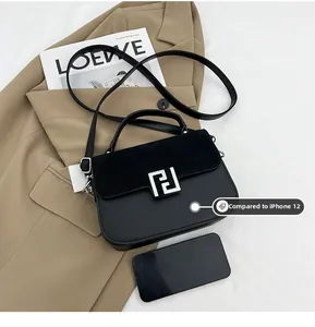 Size comparison of black matte leather handbag next to an iPhone 12 for scale