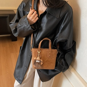 Sac seau en cuir mat caramel avec un charm monstre poilu et des rivets métalliques