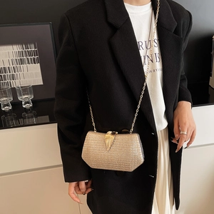Glittering gold hardshell evening clutch with metallic leaf clasp and chain strap