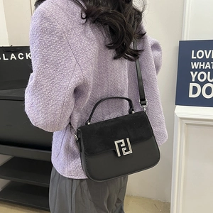 Classic black leather and suede crossbody bag with metallic buckle shown on model