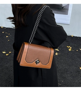 Detailed view of brown woven texture and silver chain strap on vintage shoulder bag