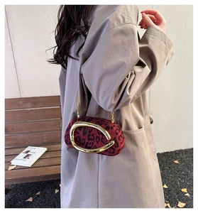 Detail of red leopard print suede crossbody bag with gold metal handle and chain strap