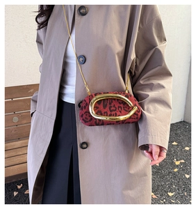 Detail of red leopard print crossbody bag with gold ring and metal chain strap