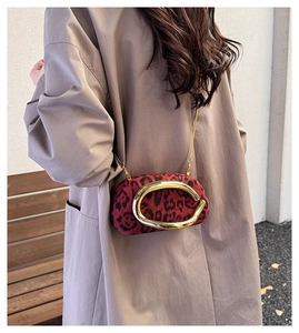 Detail of red leopard print crossbody bag with gold ring hardware and chain strap