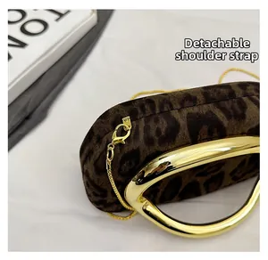 Detail of leopard print suede clutch with gold handle and detachable chain strap