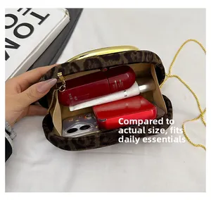 Detailed interior view of leopard print clutch showing storage for phone and cosmetics