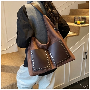 Detail of vintage brown suede hobo bag with silver metallic rivets and double pockets