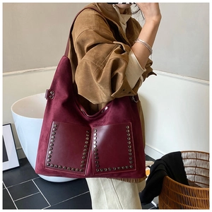 Close-up of vintage burgundy hobo bag with retro rivets and dual front pockets