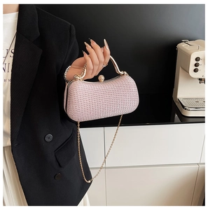 Detailaufnahme der rosa Glitzer-Abendtasche mit goldenem Metallgriff und Perlenverschluss