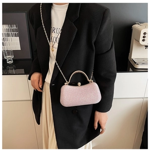 Rosa Pailletten-Clutch mit Goldgriff und Kugelverschluss am Modell getragen
