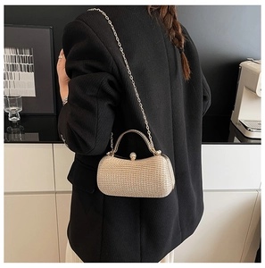 Detailansicht einer goldenen Abendtasche mit Glitzer, Strassverschluss und Kette