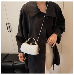 Detailansicht der silbernen Pailletten-Abendtasche mit Metallgriff und Kette an einem Model