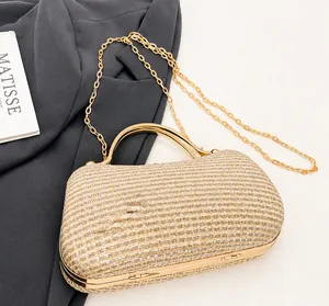 Detailansicht der champagnergoldenen Abendtasche mit strukturiertem Stoff und Metallgriff