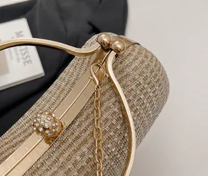 Detail der eleganten goldenen Abendtasche mit Glitzerstruktur und Kristallverschluss
