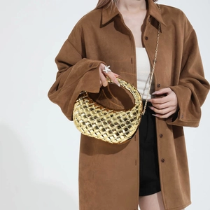 Borsa hobo intrecciata dorata alla moda con tracolla a catena indossata da una modella