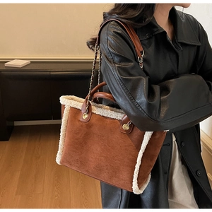 Detail of winter suede tote bag with white faux shearling trim and gold chain strap