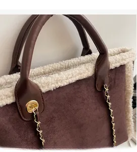 Detail of brown suede tote bag with cream fleece trim and gold chain leather handle