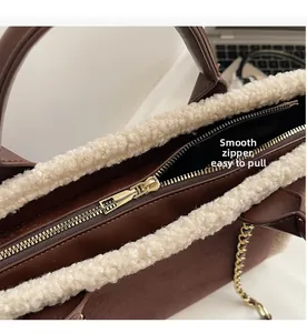 Detailed view of the gold zipper and beige faux shearling trim on dark brown bag