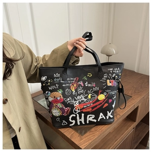 Détail du sac seau noir avec motifs graffiti d'ours colorés et texture en cuir grainé