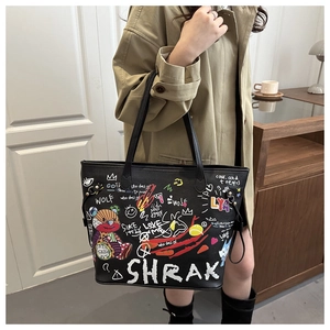 Détail d'un sac cabas en cuir noir avec graffitis d'ours colorés et imprimés urbains