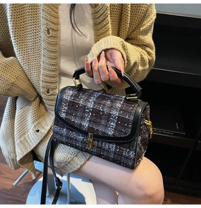 Detailansicht der braunen Tweed-Handtasche mit goldenem Drehverschluss und Lederkante