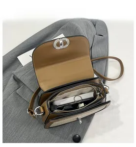 Interior view showing the dual compartments and zipper pocket of the brown saddle bag