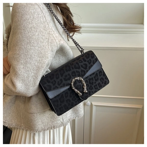 Detail of vintage leopard print crossbody bag with silver tiger head buckle and metal chain