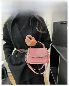 Detailed view of pink textured saddle bag with metallic double-ring buckle on model