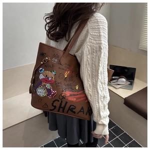 Gros plan d'un sac cabas en cuir marron avec graffiti colorés et motif d'ours
