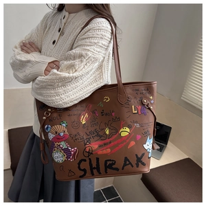 Vue détaillée du sac cabas en cuir marron avec graffitis d'ours et motifs artistiques