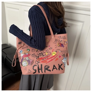 Détail du sac cabas rose avec graffitis d'ours cartoon et bandoulière en cuir
