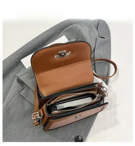Détail de l'intérieur du sac besace marron montrant la capacité et la poche zippée