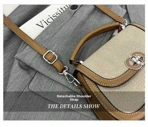 Detail view of the detachable brown leather strap and silver metal buckle on a saddle bag