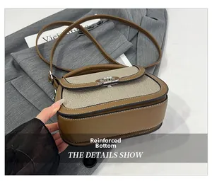 Detail showing the reinforced bottom and metal rotary clasp of the brown saddle bag