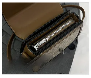 Detail of internal compartment with silver zipper and bicolor stitching on the saddle bag